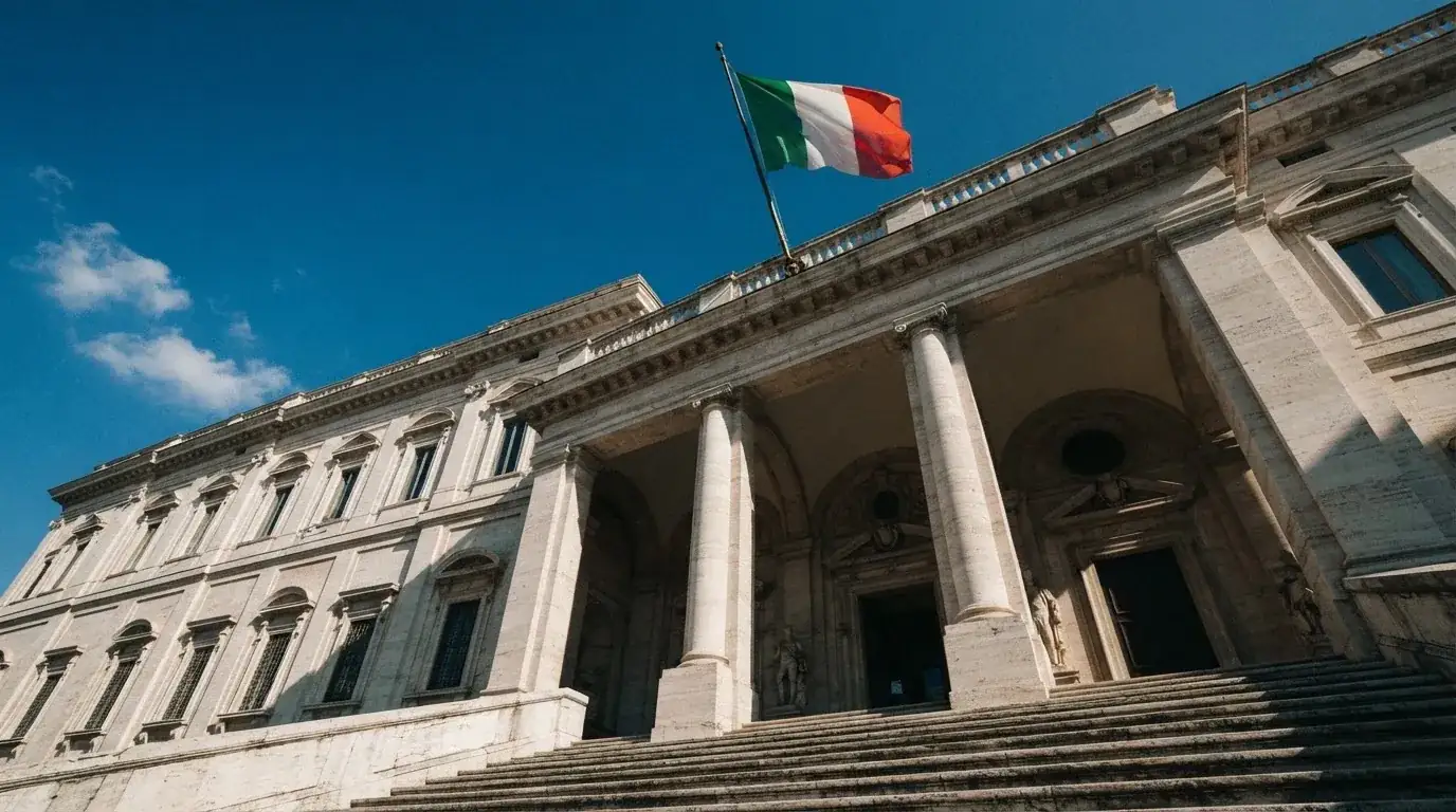 Un edificio governativo italiano con bandiera al vento fotografato dal basso in una giornata di sole.